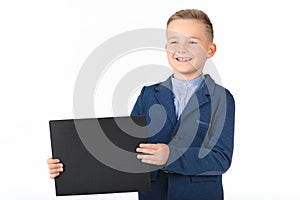 Happy exited caucasian young boy showing and displaying blank black board ready for your text or product