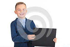 Happy exited caucasian young boy showing and displaying blank black board ready for your text or product