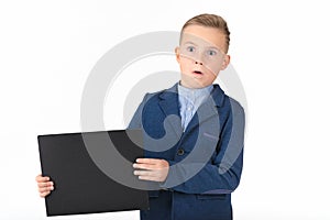 Happy exited caucasian young boy showing and displaying blank black board ready for your text or product