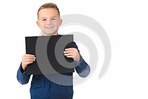 Happy exited caucasian young boy showing and displaying blank black board ready for your text.White background