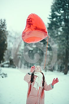 Happy exited girl with Valentine heart balloons outdoor. Valentine`s day concept. Copy space.