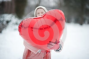 Happy exited girl with Valentine heart balloons outdoor. Valentine`s day concept. Copy space.