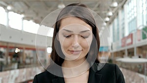 Happy exotic woman shopping at the mall, close portrait of confident smiling business woman in store or airport terminal