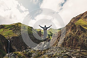 Contento ricercatore giovane uomo piedi elevato le spalle estate montagne posteriore 