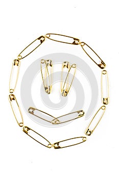 Happy face of gold colored safety pins