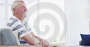 Happy, face and senior man on a chair with positive attitude, good mood or chilling at home. Smile, portrait and elderly