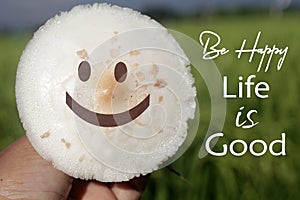 Happy face on a white mushroom on the grass with positive inspirational messages - Be happy. Life is good. Happiness with a smile
