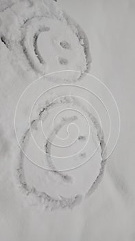 Happy faces made in a stone covered by snow