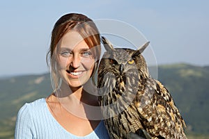 Happy falconer with an eagle owl looking at camera