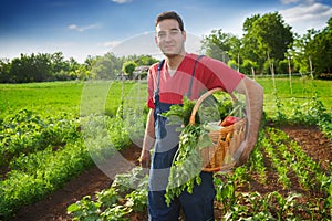 Happy famer holding basket with vegetables