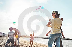Happy families flying with kite and having fun on the beach - Parents playing with children outdoor - Love, and weekend holidays