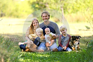 Happy Family of 5 People and Dog in Sunny Garden