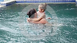 Happy family, active father with little child, adorable toddler daughter, having fun in swimming pool.