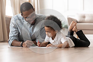 Happy family african dad and cute kid boy drawing together