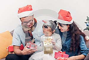 Happy family Asia family wear santa claus hat exchange Christmas