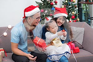 Happy family Asia family wear santa claus hat exchange Christmas