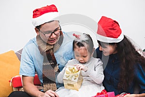 Happy family Asia family wear santa claus hat exchange Christmas