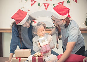 Happy family Asia family wear santa claus hat unwrap Christmas g
