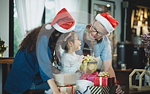 Happy family Asia family wear santa claus hat unwrap Christmas g