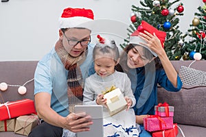 Happy family Asia selfie with tablet at sofa,father and mother w