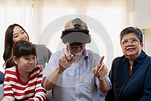 Happy family asian aged grandfather, grandmother have fun, smiling parent and sisters, man wearing virtual reality glasses, using
