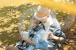 Happy family asian senior couple drinking coffee in park retirement smile in nature park