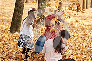 Happy family is in autumn city park. Children and parents. They posing, smiling, playing and having fun. Bright yellow trees