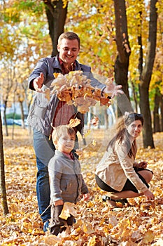 Happy family is in autumn city park. Children and parents. They posing, smiling, playing and having fun. Bright yellow trees