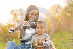 Happy family on autumn walk. Young beautiful mother with little son enjoy nature