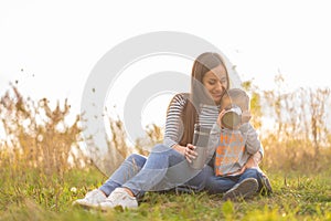 Happy family on autumn walk. Young beautiful mother with little son enjoy nature