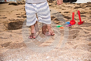 Happy family baby boy and father walk barefoot on sand beach