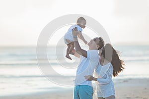 Happy family and baby enjoying sunset in the summer leisure