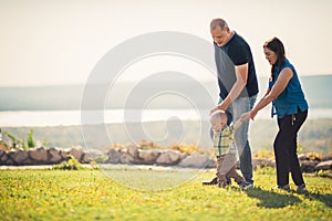 Happy family with baby on green grass