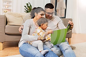 Happy family with baby reading book at home