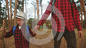 Happy family with backpacks go on a trip through the park travel. kid tourist dream adventure concept. dad and kid