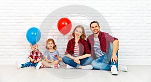 Happy family with ballons. mother, father, son, daughter on a white blank wall