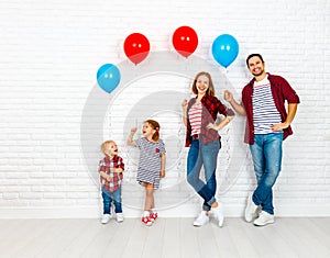 Happy family with ballons. mother, father, son, daughter on a white blank wall