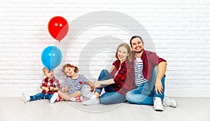 Happy family with ballons. mother, father, son, daughter on a white blank wall