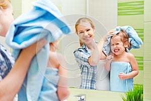 Happy family in bathroom. mother of a child with towel dry hair