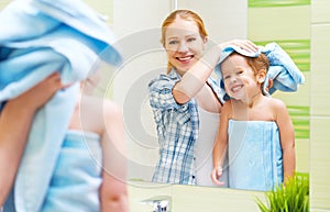 Happy family in bathroom. mother of a child with towel dry hair photo