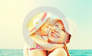 Happy family on beach. baby daughter kissing mother