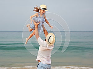 Happy family at beach. father and child daughter hug at sea