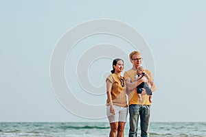 Happy family on the beach.  Father, mother and baby having fun on summer vacation. Holiday travel concept