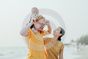 Happy family on the beach.  Father, mother and baby having fun on summer vacation. Holiday travel concept