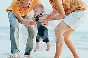 Happy family on the beach.  Father, mother and baby having fun on summer vacation. Holiday travel concept