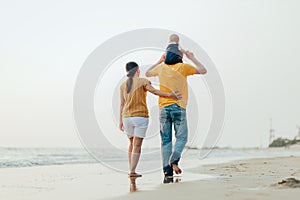 Happy family on the beach.  Father, mother and baby having fun on summer vacation. Holiday travel concept