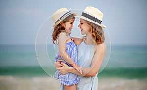 Happy family at beach. mother and child daughter hug at sea