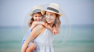 Happy family at beach. mother and child daughter hug at sea