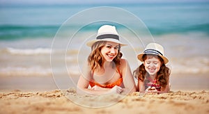 Happy family at beach. mother and child daughter hug at sea