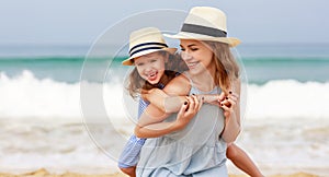 Happy family at beach. mother and child daughter hug at sea